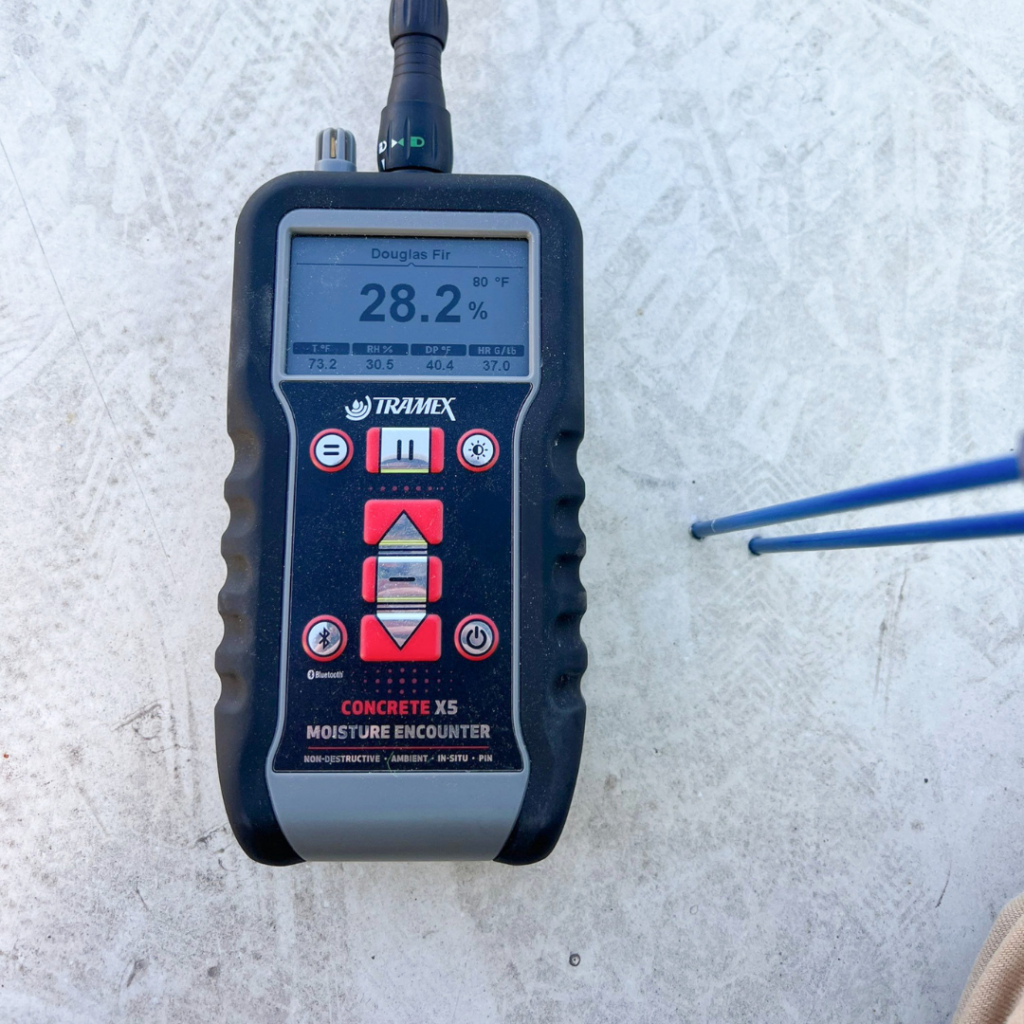 Moisture meter on concrete showing 28.2% moisture with two probes connected (Tramex Concrete X5)
