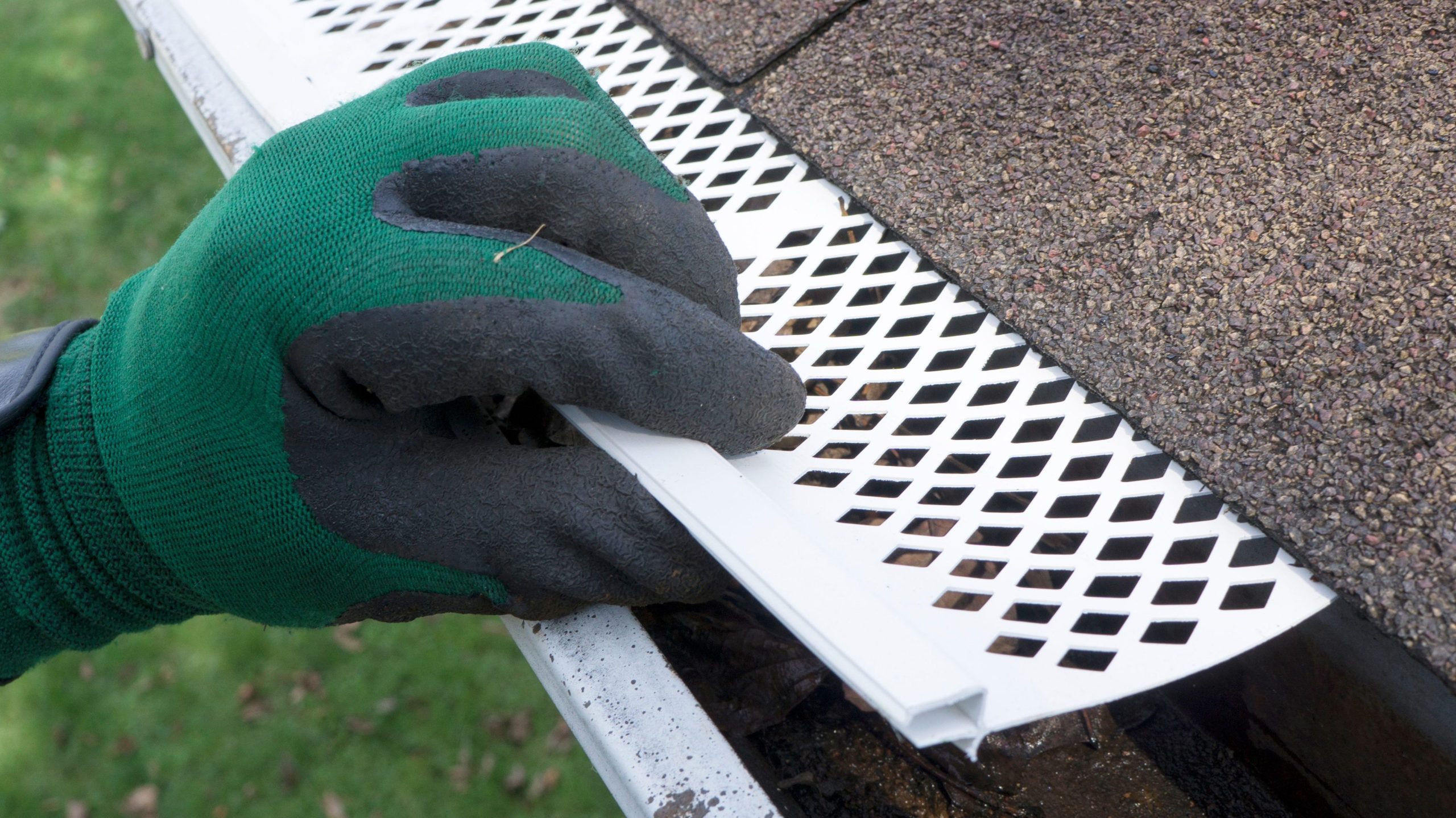 Contractor adjusts gutter guards to fit them and protect the gutter from debris.